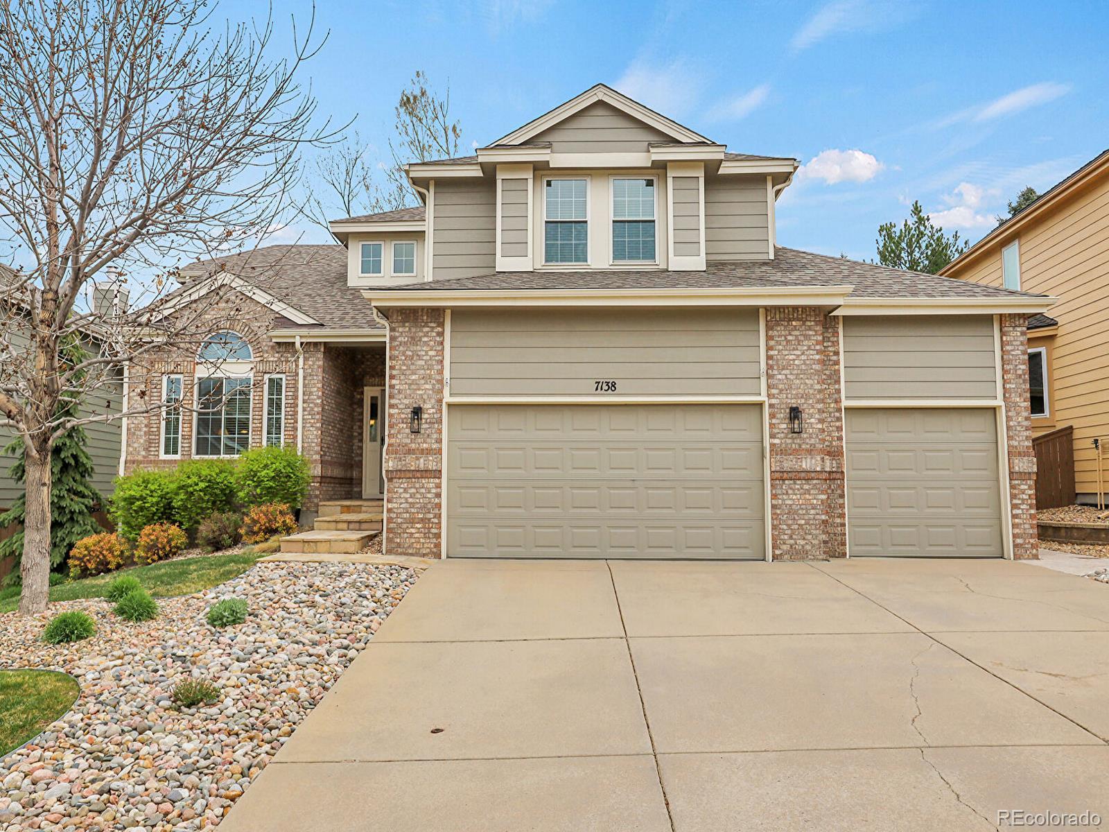 7138 Mountain Brush Circle Highlands Ranch, CO 80130 - Photo 2 of 50 a front view of a house with a yard and garage