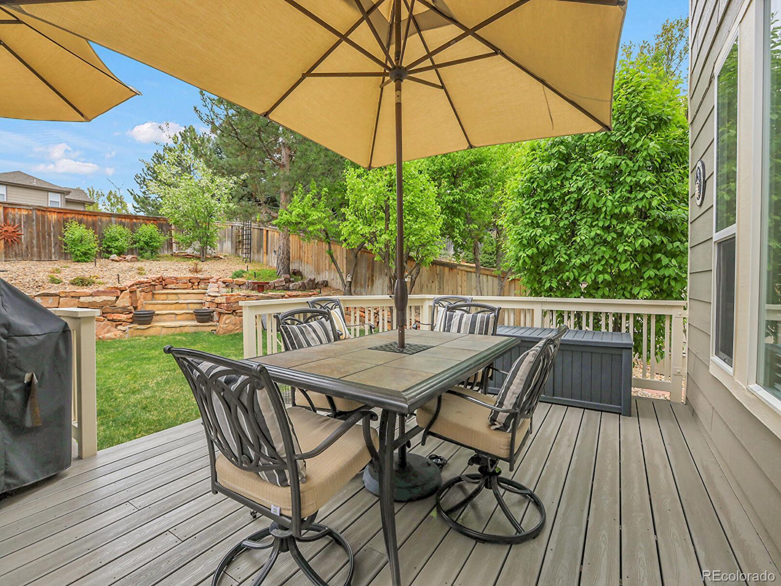 7138 Mountain Brush Circle Highlands Ranch, CO 80130 - Photo 42 of 50 a view of a patio with a table and chairs under an umbrella
