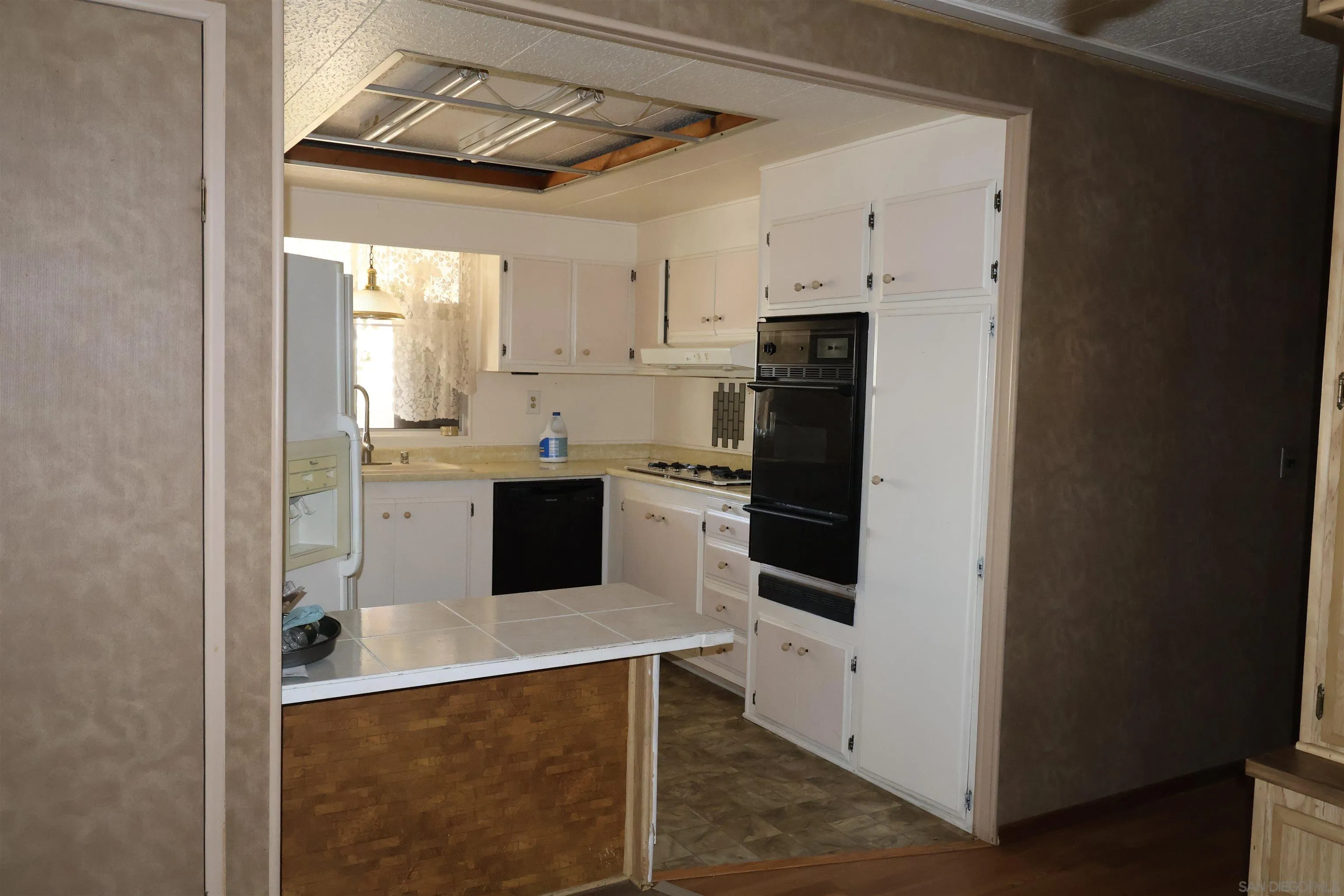 4747 Oak Crest Road, Unit 48 Fallbrook, CA 92028 - Photo 9 of 22 a kitchen with stainless steel appliances a stove a sink and white cabinets