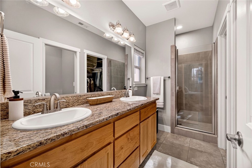 2855 Pin Oak Lane Chico, CA 95928 - Photo 18 of 48 a bathroom with a granite countertop sink a mirror and a shower