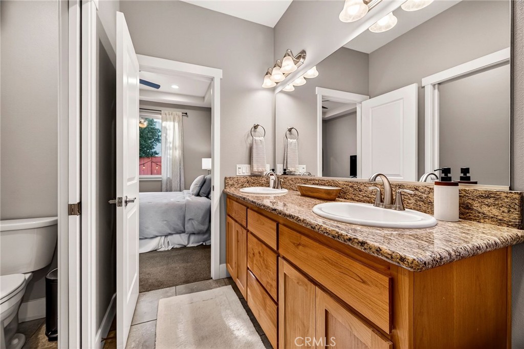 2855 Pin Oak Lane Chico, CA 95928 - Photo 19 of 48 a en suite bathroom with a granite countertop sink and a mirror
