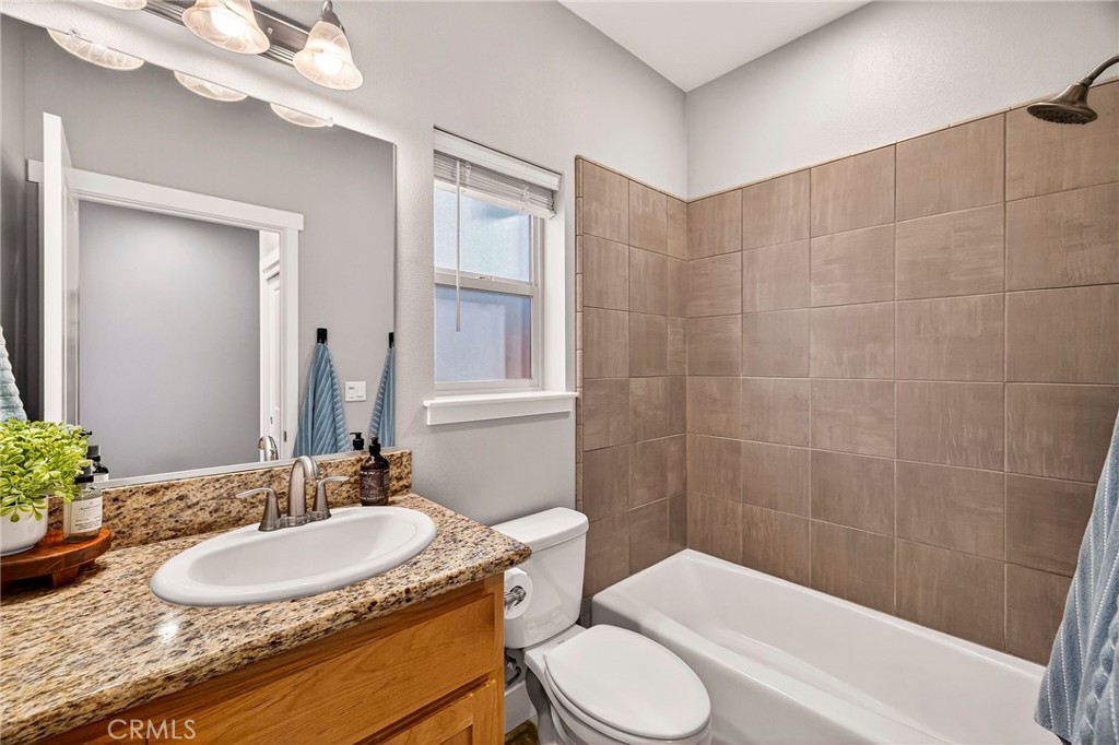 2855 Pin Oak Lane Chico, CA 95928 - Photo 27 of 48 a bathroom with a granite countertop sink toilet a mirror and shower