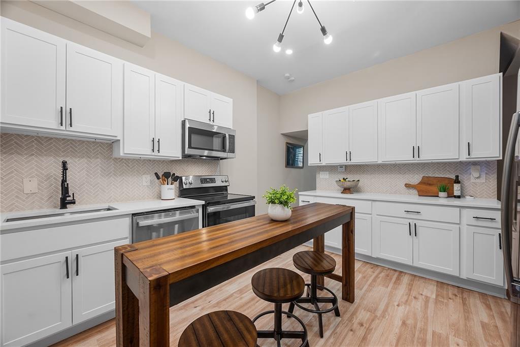 106 44th Street Pittsburgh, PA 15201 - Photo 9 of 41 a kitchen with stainless steel appliances granite countertop a sink a stove a refrigerator cabinets and chairs