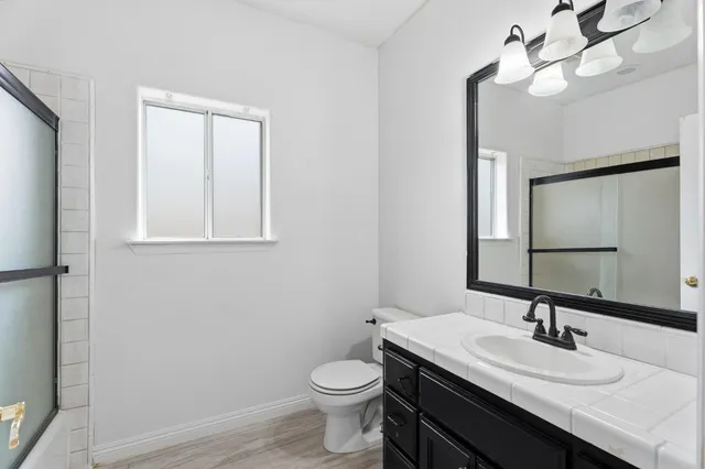 a bathroom with a toilet a sink and mirror