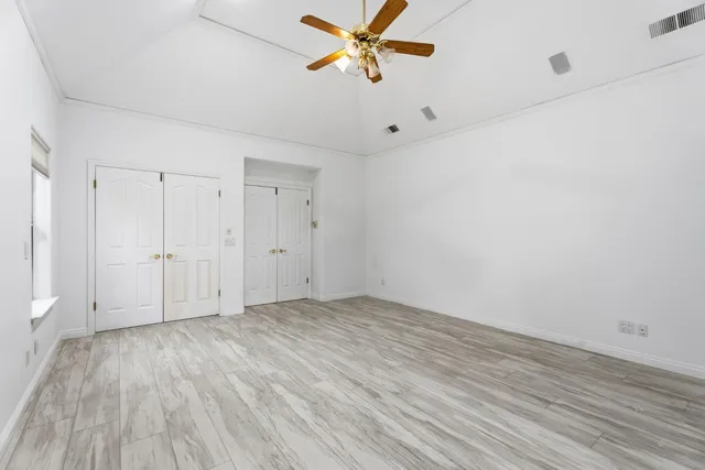 a view of a room with wooden floor and a ceiling fan