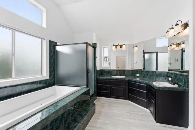 a spacious bathroom with a granite countertop tub sink and mirror