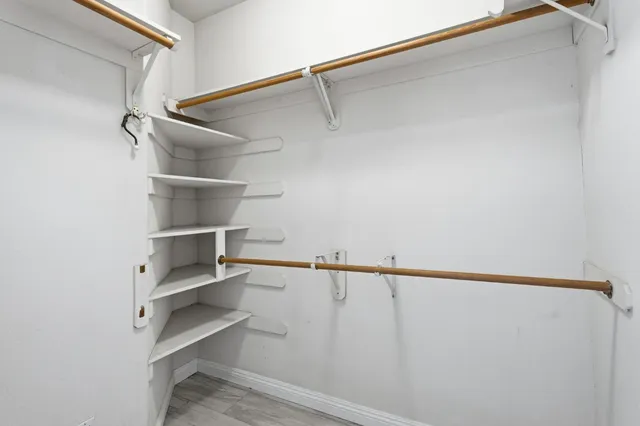 a view of walk in closet with empty racks