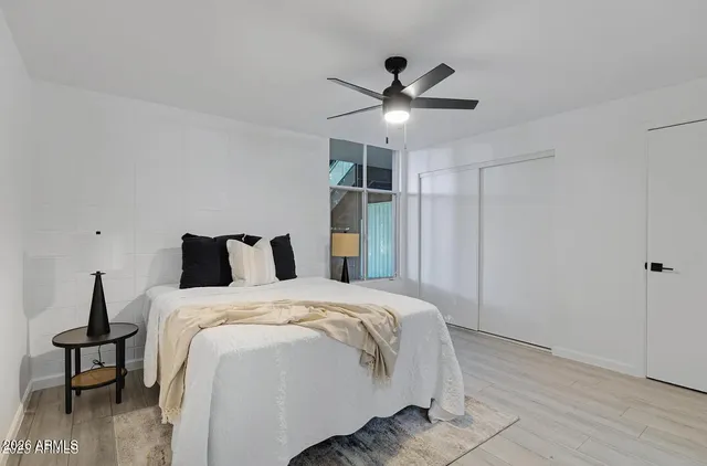 a bedroom with a bed and a ceiling fan