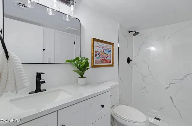 an empty room with wooden floor ceiling fan and windows