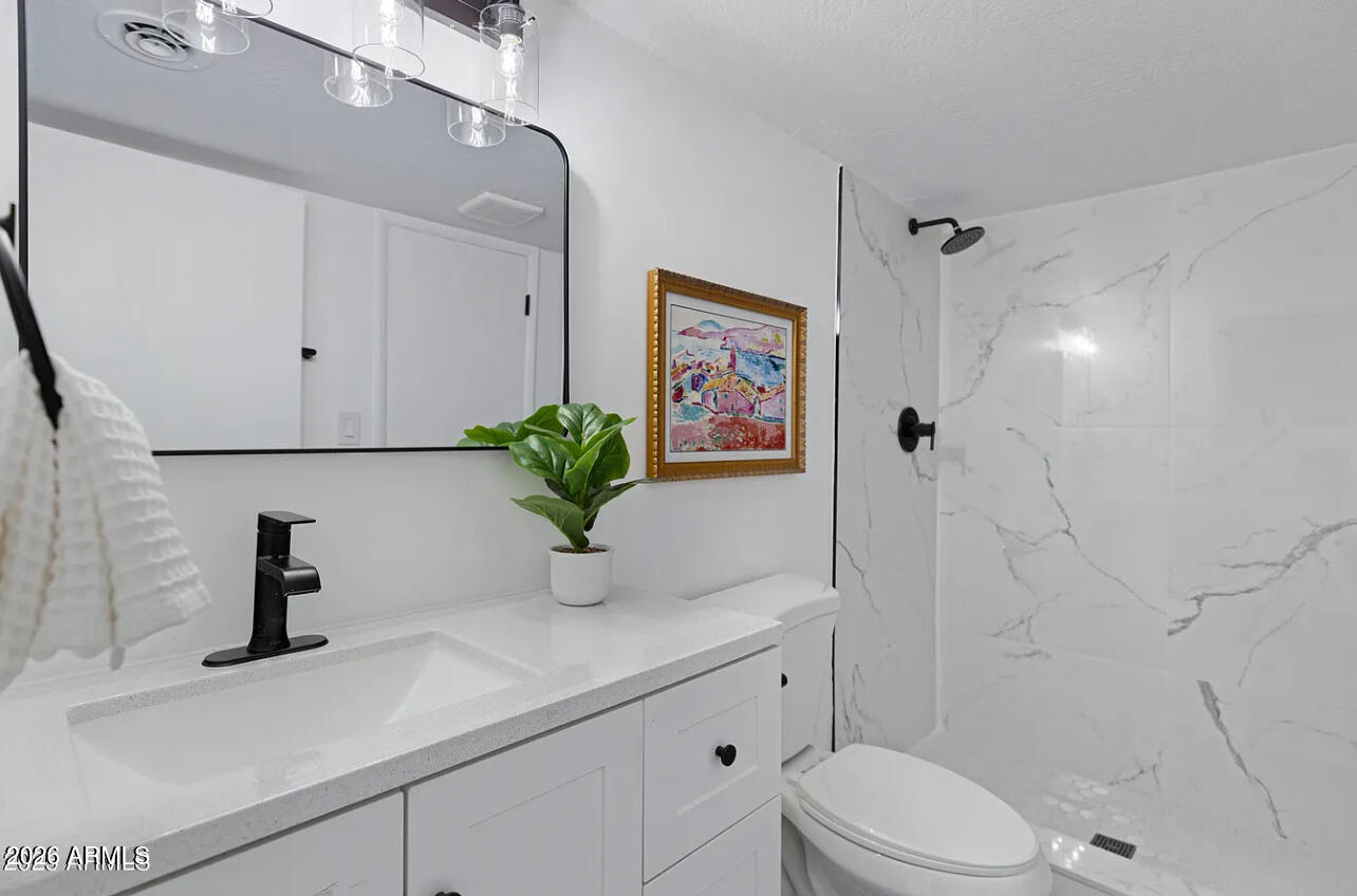 1101 East Bethany Home Road, Unit 15 Phoenix, AZ 85014 - Photo 14 of 16 a bathroom with a sink a toilet and shower