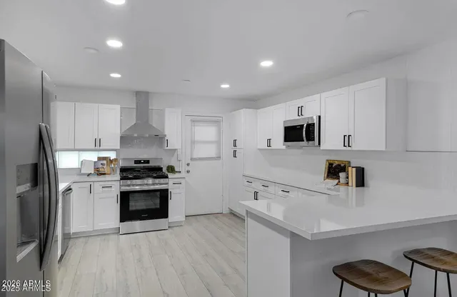 a kitchen with stainless steel appliances a refrigerator sink and stove