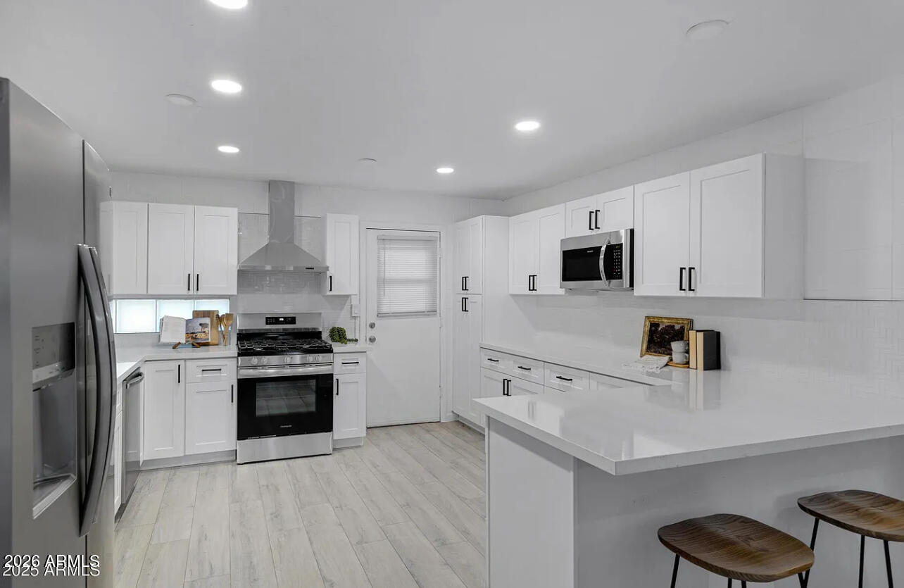 1101 East Bethany Home Road, Unit 15 Phoenix, AZ 85014 - Photo 8 of 16 a kitchen with stainless steel appliances a sink stove and refrigerator