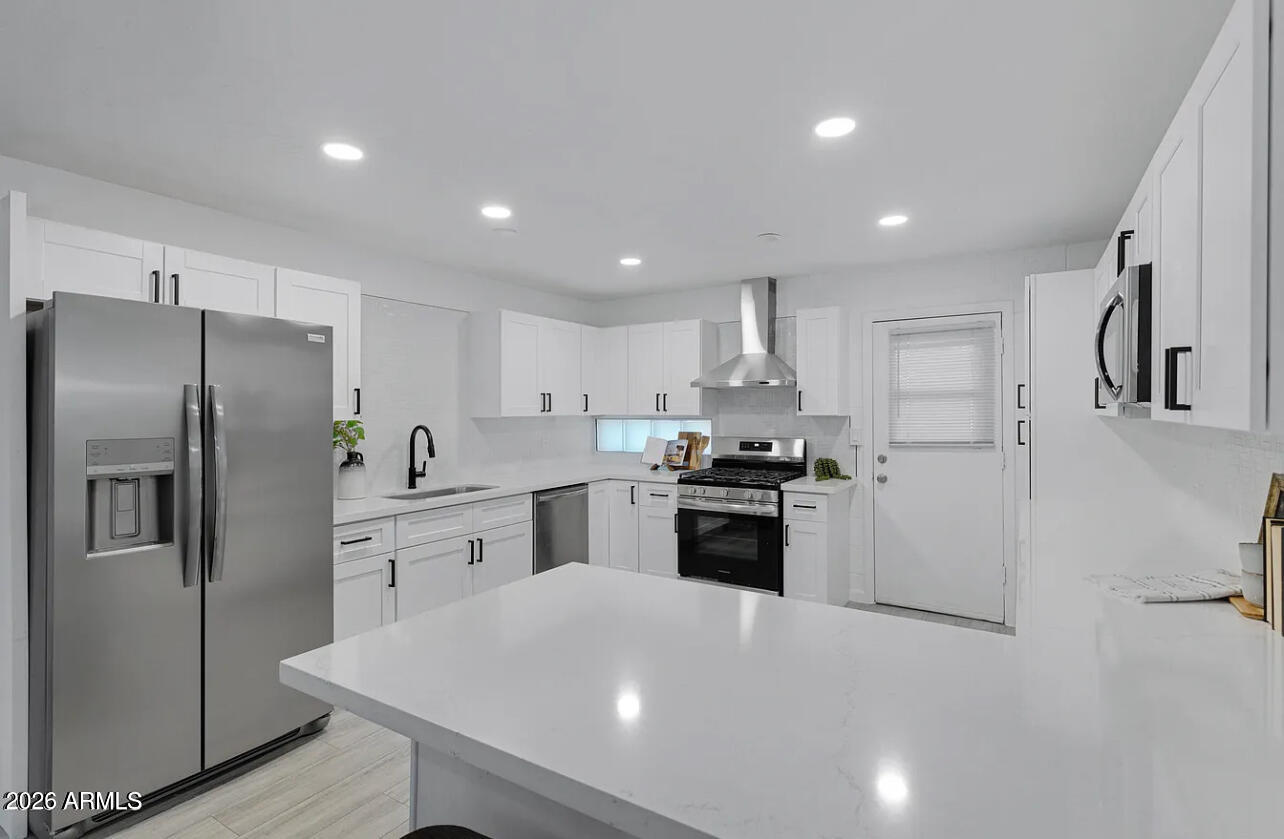 1101 East Bethany Home Road, Unit 15 Phoenix, AZ 85014 - Photo 9 of 16 a kitchen with stainless steel appliances a refrigerator sink and stove