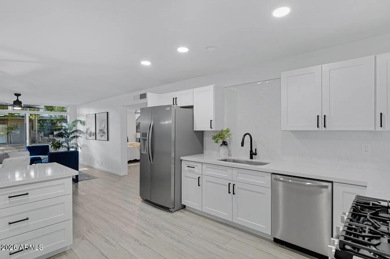 1101 East Bethany Home Road, Unit 15 Phoenix, AZ 85014 - Photo 10 of 16 a kitchen with white cabinets and stainless steel appliances