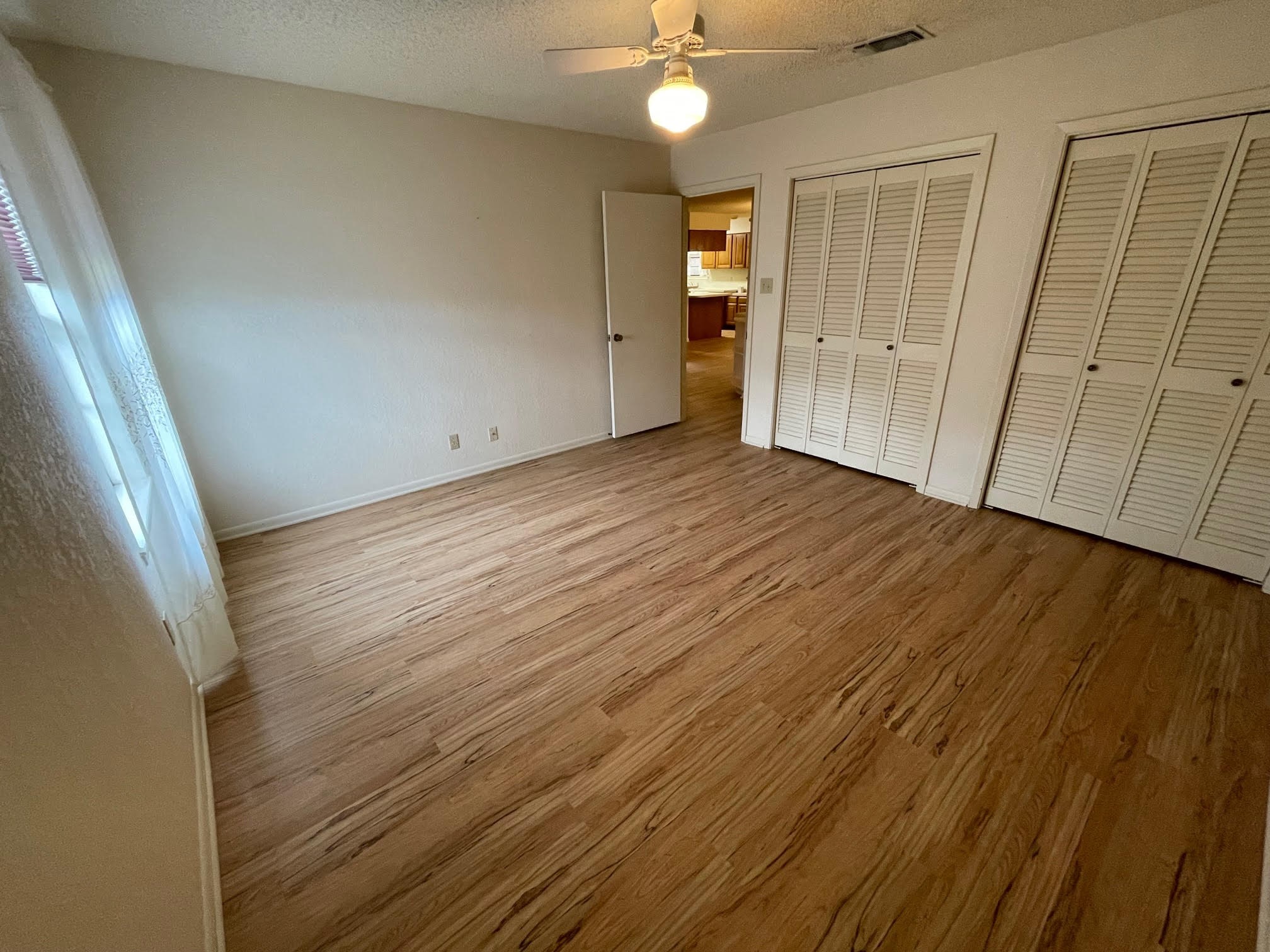 1732 Ave C, Unit A El Campo, TX 77437 - Photo 14 of 22 wooden floor in an empty room with a window