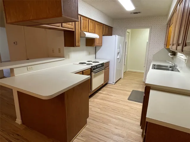 a kitchen with a stove a refrigerator and a sink