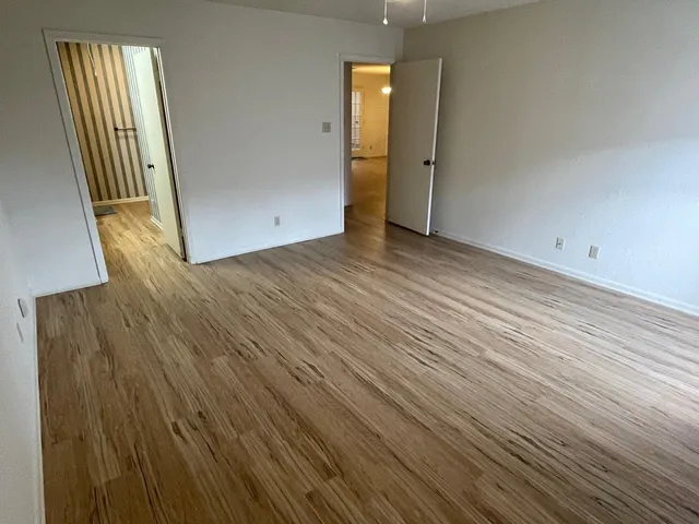 an empty room with wooden floor and entrance