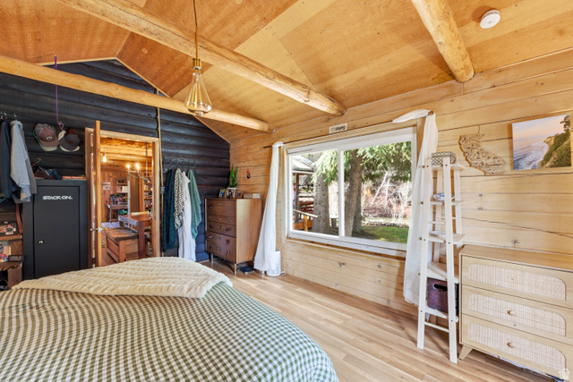 6631 Pine Springs Road Kamas, UT 84036 - Photo 13 of 48 Bedroom featuring wood-type flooring, vaulted ceiling with beams, rustic walls, wooden ceiling, and a closet