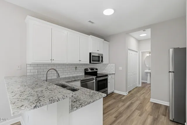 a kitchen with granite countertop a sink stove and refrigerator