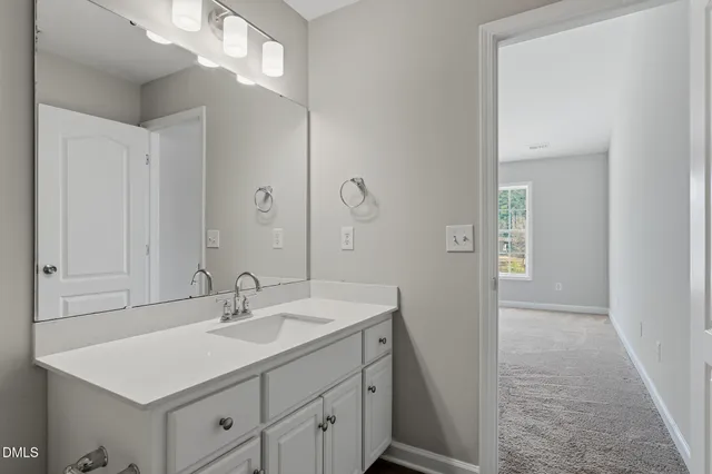 a bathroom with a sink a light fixture and a mirror