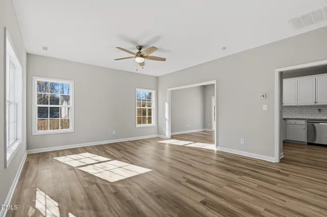 a view of empty room with wooden floor and window