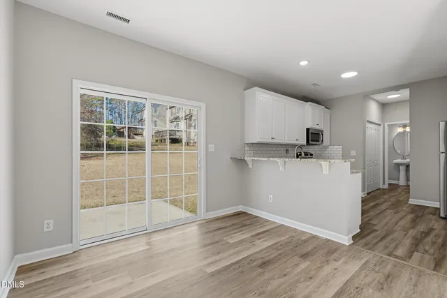 a view of a kitchen with wooden floor and electronic appliances