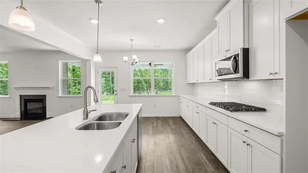 a kitchen with stainless steel appliances kitchen island a white stove top oven a sink a counter space and cabinets