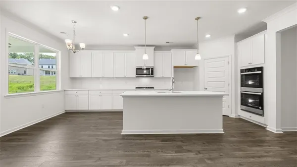 a large kitchen with stainless steel appliances granite countertop a stove a sink and a refrigerator
