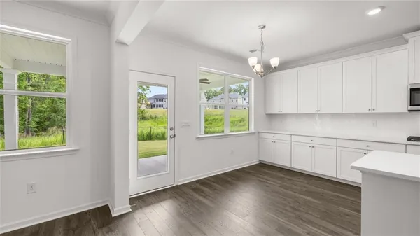 a kitchen with wooden floors and white walls