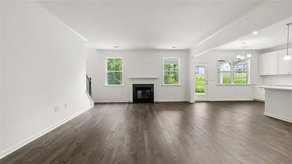 an empty room with wooden floor and a fireplace