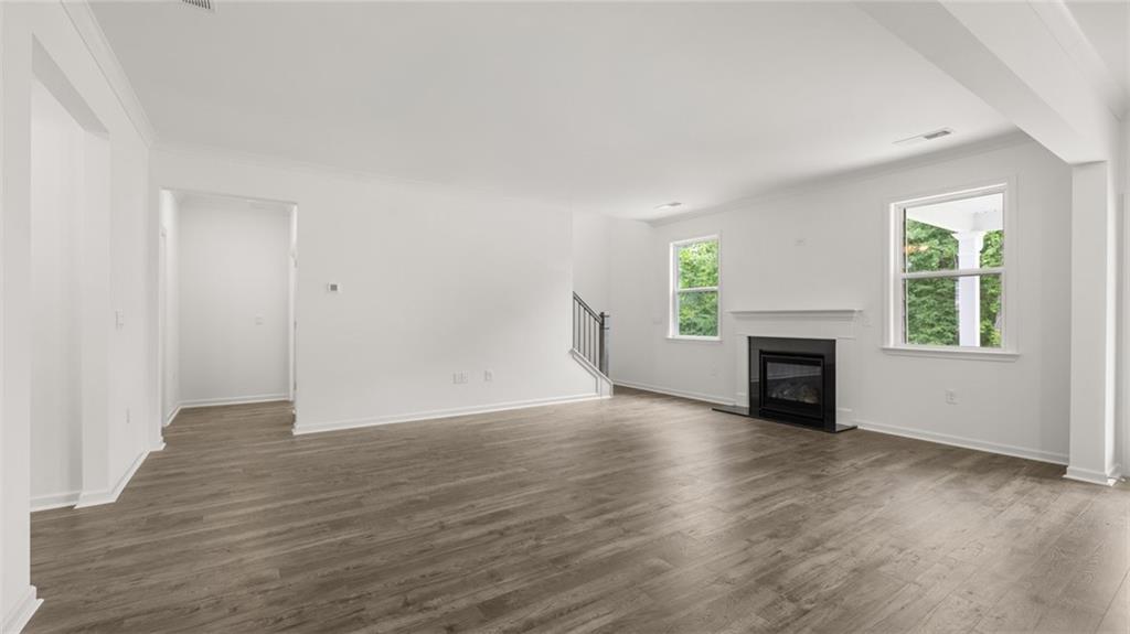 1775 Goodwin Drive Hampton, GA 30228 - Photo 18 of 49 an empty room with wooden floor fireplace and windows
