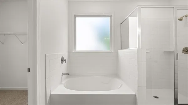 a white bath tub sitting next to a shower