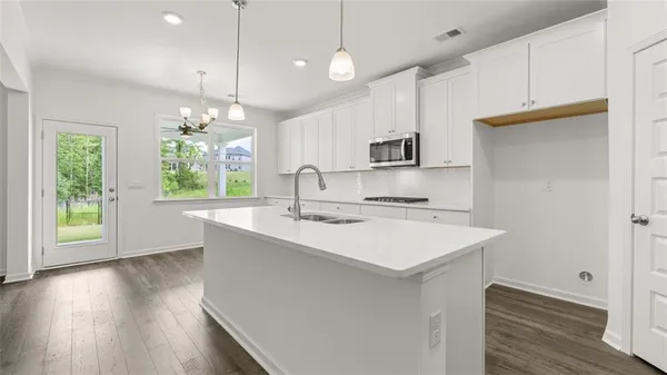 a kitchen with a sink a window and wooden floor