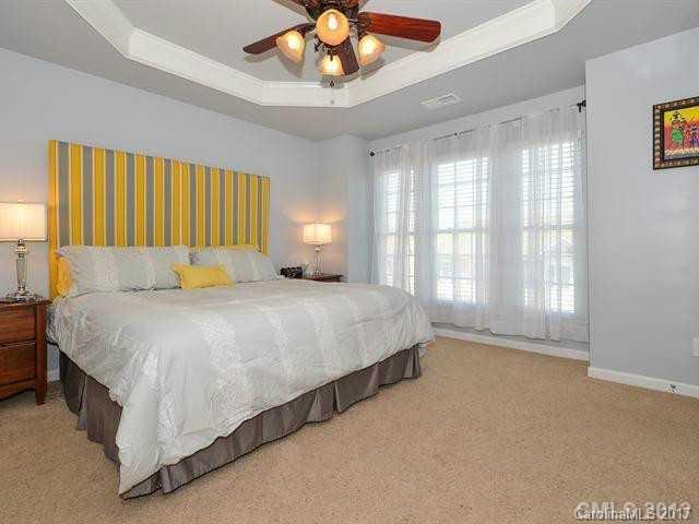 809 Granby Drive, Unit 38 Fort Mill, SC 29708 - Photo 12 of 15 a spacious bedroom with a large bed and a chandelier fan