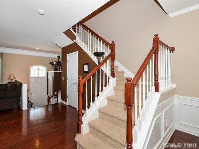 809 Granby Drive, Unit 38 Fort Mill, SC 29708 - Photo 3 of 15 a view of staircase with lots of frames on wall and wooden floor
