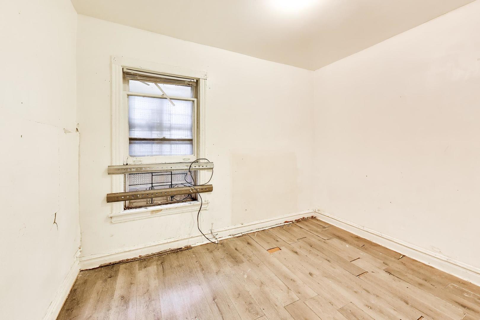 5738 South Ada Street Chicago, IL 60636 - Photo 14 of 22 an empty room with wooden floor and windows