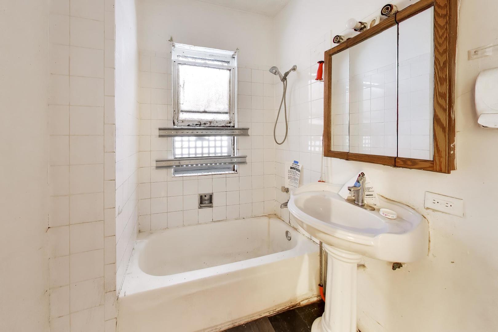 5738 South Ada Street Chicago, IL 60636 - Photo 18 of 22 a bathroom with a sink a mirror and a bathtub