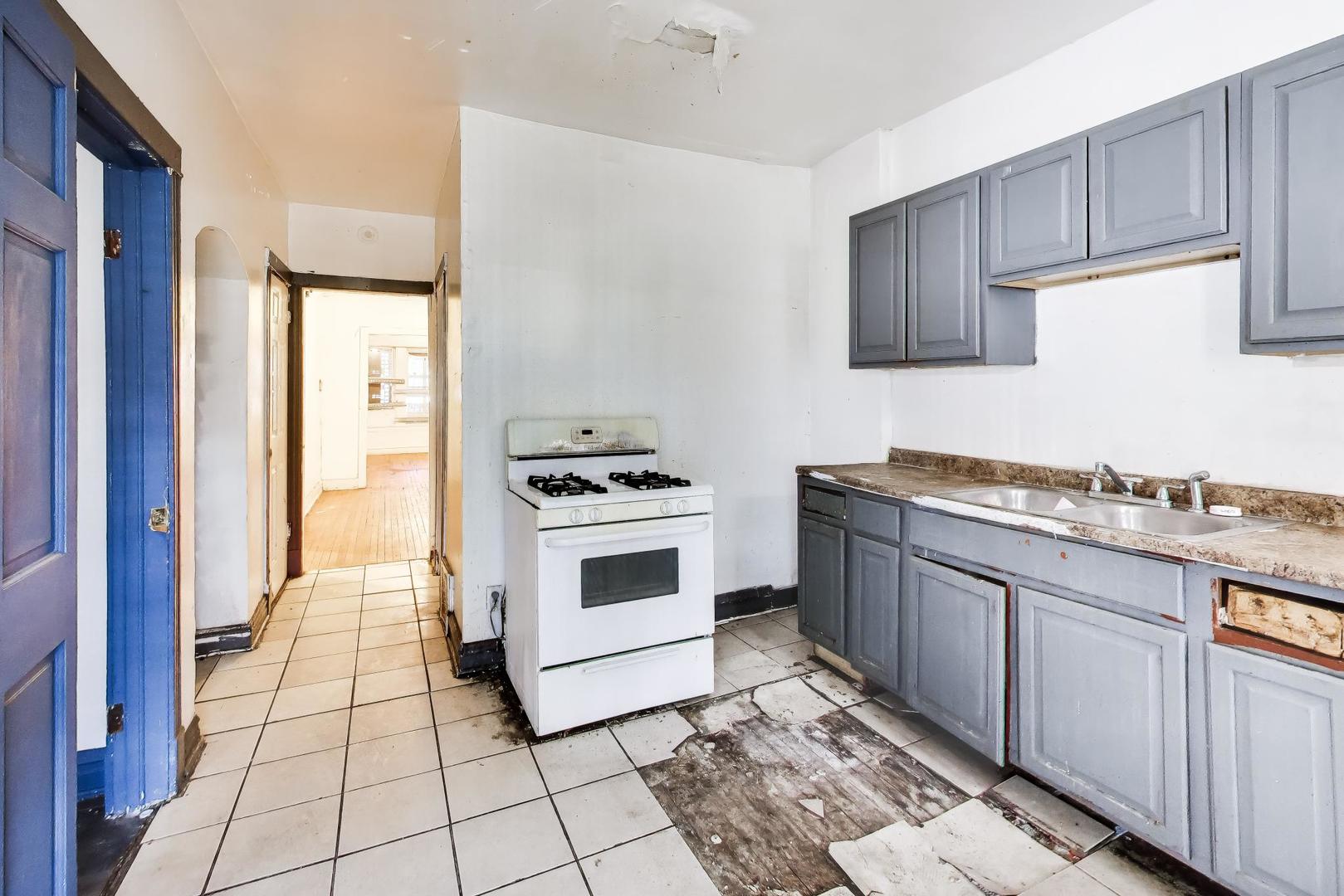 5738 South Ada Street Chicago, IL 60636 - Photo 10 of 22 a kitchen with a stove sink and cabinets