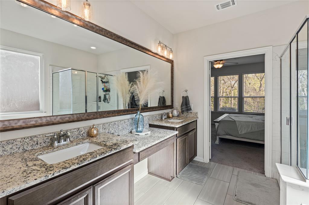 9517 Sunset Lane Oak Point, TX 75068 - Photo 23 of 40 9517 Sunset Lane, Oak Point, TX 75068 - primary bathroom - Primary bathroom featuring ensuite bathroom, double vanity, a shower stall, ceiling fan, and light tile patterned floors