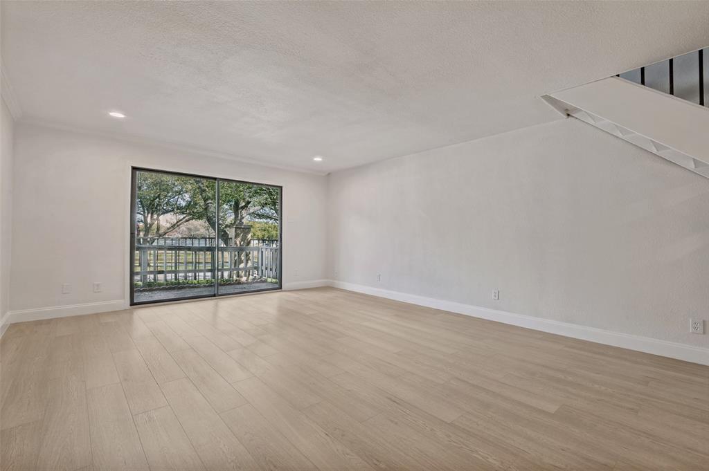 4505 North O'Connor Road, Unit 1121 Irving, TX 75062 - Photo 18 of 34 a view of an empty room with wooden floor and a window