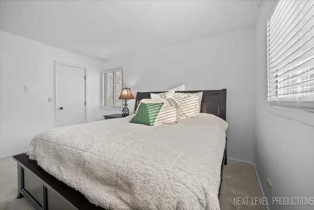 a large bed sitting in a bedroom next to a window