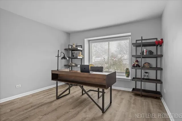 a view of a workspace with furniture and a window