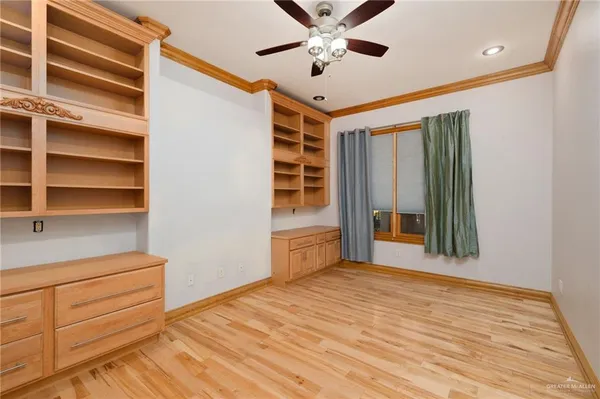 a view of an empty room with cabinet and a window