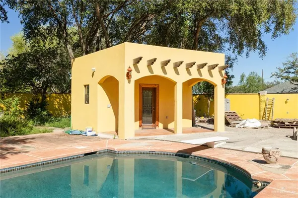 a view of pool with brick wall and seating area