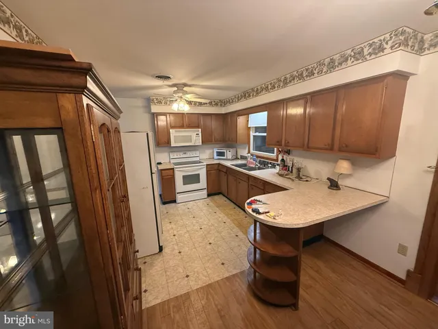 a kitchen with stainless steel appliances a sink a stove a refrigerator cabinets and wooden floor