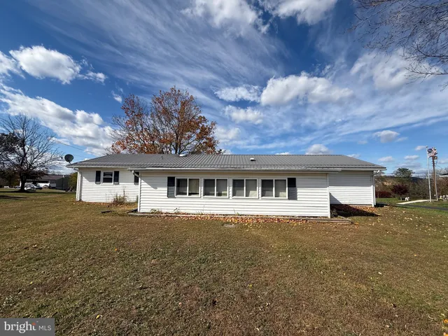 a front view of house with yard and trees around
