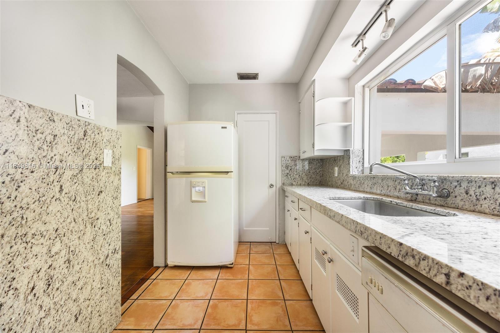 451 Southwest 25th Road Miami, FL 33129 - Photo 16 of 25 a large white kitchen with a granite countertop window and a sink