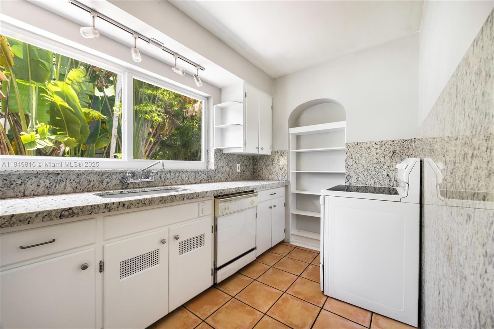 451 Southwest 25th Road Miami, FL 33129 - Photo 17 of 25 a kitchen with a stove a sink and a refrigerator