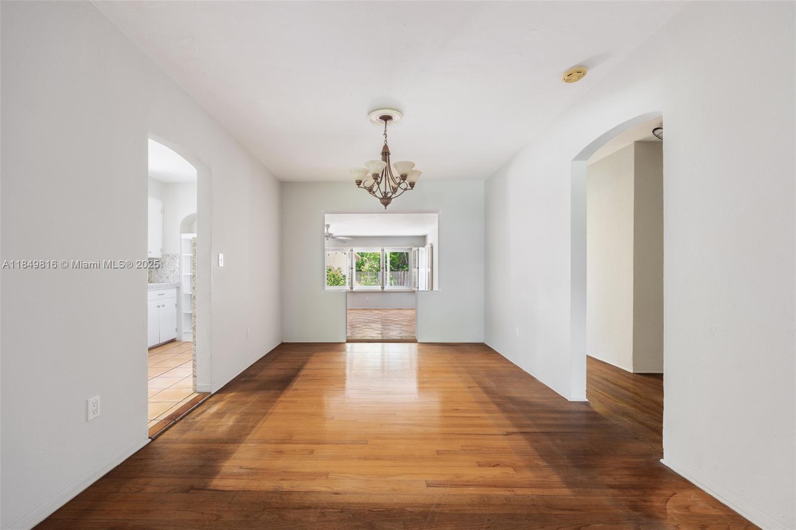 451 Southwest 25th Road Miami, FL 33129 - Photo 7 of 25 a view of an empty room with wooden floor and a window