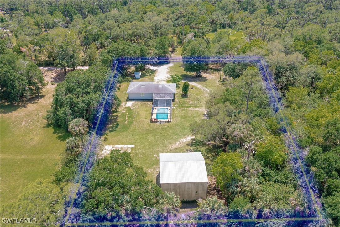 an aerial view of a house with a yard basket ball court and outdoor seating